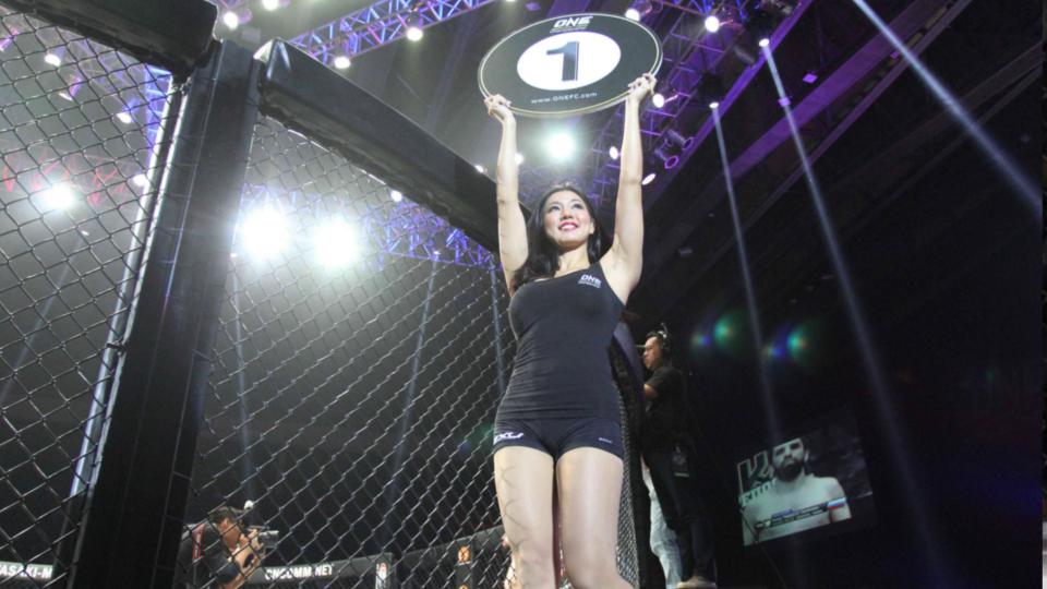 Ring Girls saat membawa papan ronde dapat menjadi pemainis di acara One Fighting Championship 2015.